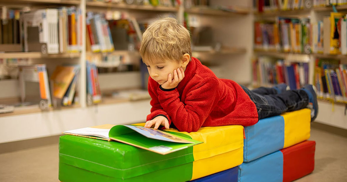 Un enfant en train de lire dans une bibliothèque